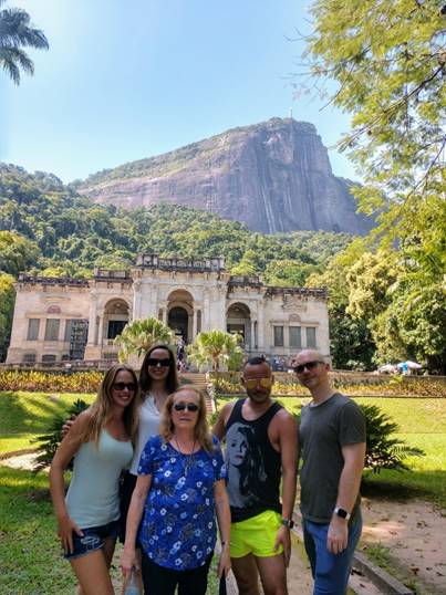 A group of people standing in front of a house

Description automatically generated