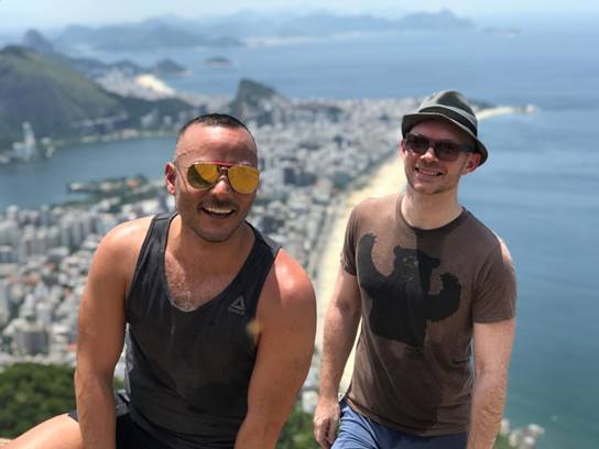 A couple of people standing next to a body of water

Description automatically generated
