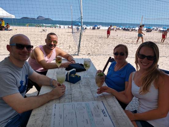 A group of people sitting at a beach

Description automatically generated