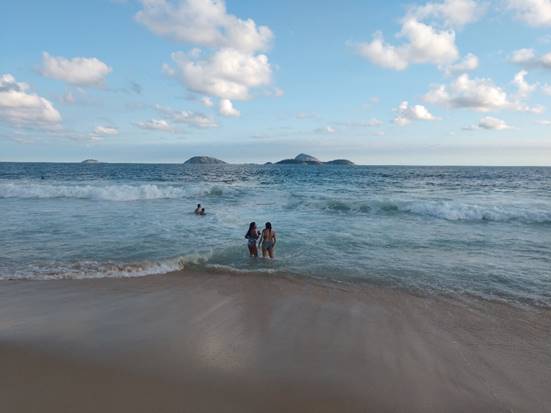 A group of people on a beach next to the ocean

Description automatically generated