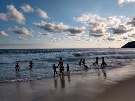 A group of people walking on a beach

Description automatically generated