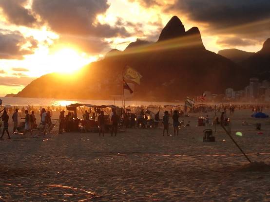 A group of people standing in front of a sunset

Description automatically generated