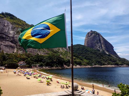 A body of water with a colorful umbrella on the beach

Description automatically generated