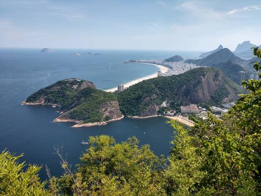 A view of a body of water with a mountain in the background

Description automatically generated