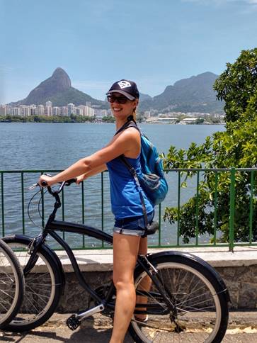 A person with a bicycle in front of a lake

Description automatically generated