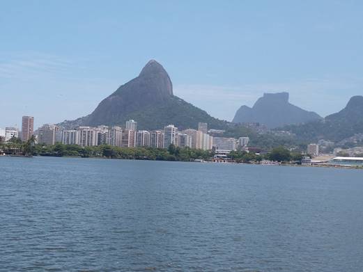 A large body of water with a mountain in the background

Description automatically generated